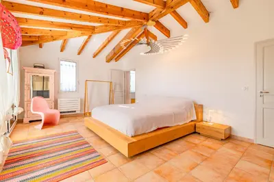 a bedroom with a bed and a chair in it at Villa La Ronde des Soleils in Coti-Chiavari