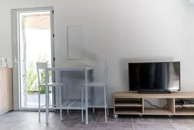 a living room with a tv and a entertainment center at Studio en pierre U Pinu, 2 personnes, Muratello, 6 Kms de Porto Vecchio in Porto-Vecchio