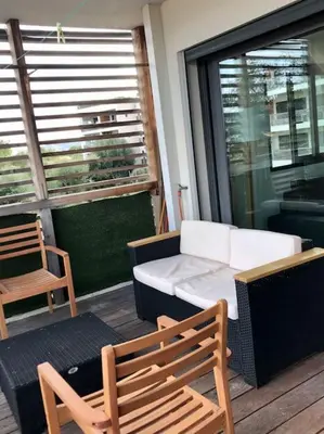 a balcony with a table and chairs and a couch at Studio Piscine, 200m port de Porto Vecchio pour 2 personnes in Porto-Vecchio