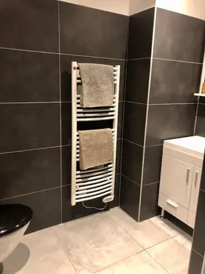 a bathroom with a towel rack on the wall at Studio Piscine, 200m port de Porto Vecchio pour 2 personnes in Porto-Vecchio