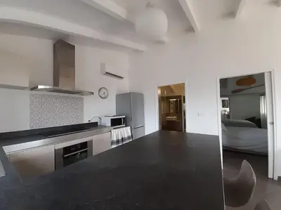 a kitchen with a black counter top in a room at Le nid d'Aigle - proche Ajaccio in Cuttoli-Corticchiato