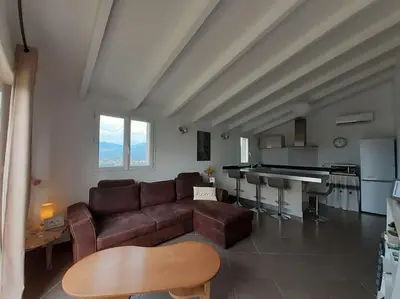 a living room with a couch and a piano at Le nid d'Aigle - proche Ajaccio in Cuttoli-Corticchiato
