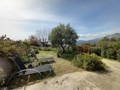 a couple of chairs sitting in a garden at Le nid d'Aigle - proche Ajaccio in Cuttoli-Corticchiato