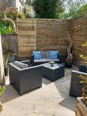 a patio with a couch and a table and a fence at Le nid d'Aigle - proche Ajaccio in Cuttoli-Corticchiato