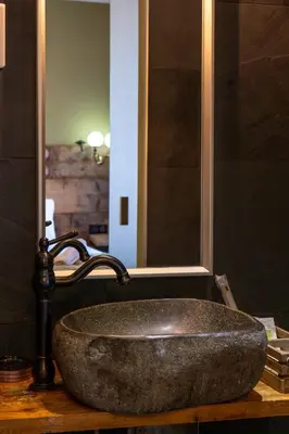 a stone sink in a bathroom with a mirror at Auberge U Mulinu in Casalabriva