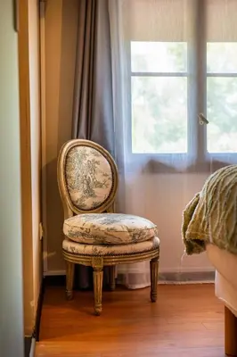 a chair sitting in front of a window at Auberge U Mulinu in Casalabriva