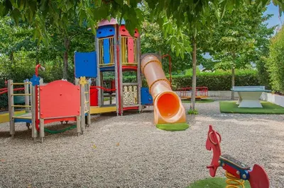 a playground with a slide in a park at Appt dans résidence avec piscines et plage privées in San-Nicolao