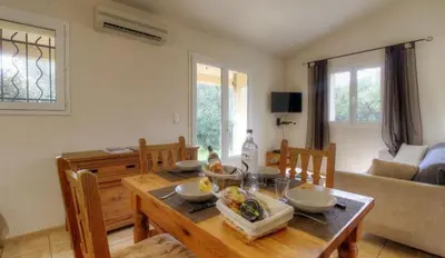 a dining room with a table and chairs and a table and chairsktop at Les bergeries d'Ogliastrello in Figari