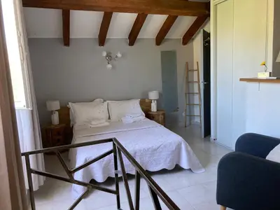 a bedroom with a bed with white sheets and pillows at Maison Kyprea: charmant appartement /duplex , spacieux, tout confort avec terrasse extérieure privée, parking privatif , vue pittoresque sur la citadelle de Corté et les montagnes. in Corte