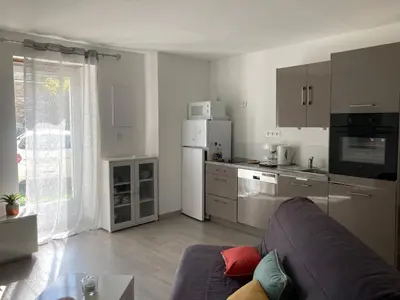a living room with a couch and a kitchen at Maison Kyprea: charmant appartement /duplex , spacieux, tout confort avec terrasse extérieure privée, parking privatif , vue pittoresque sur la citadelle de Corté et les montagnes. in Corte