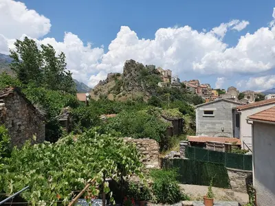 a view of a village with a mountain at Maison Kyprea: charmant appartement /duplex , spacieux, tout confort avec terrasse extérieure privée, parking privatif , vue pittoresque sur la citadelle de Corté et les montagnes. in Corte