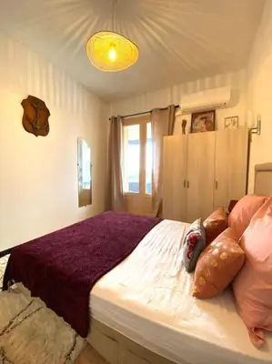 a bedroom with a large bed with a purple blanket at Maison de village en granite in Porto-Vecchio