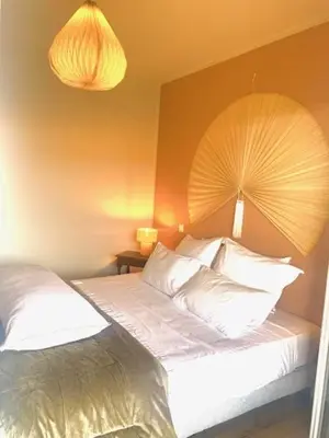 a bedroom with a bed with a fan on the wall at A CASA DI MAMMA in Pianottoli-Caldarello