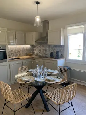 a kitchen with a table with plates and glasses on it at A CASA DI MAMMA in Pianottoli-Caldarello
