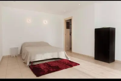 a white bedroom with a bed and a red rug at Chez telou in Borgo