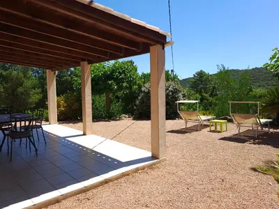 a patio with a table and chairs under a pavilion at Villa avec piscine hors sol à 10mn de la plage in Lecci