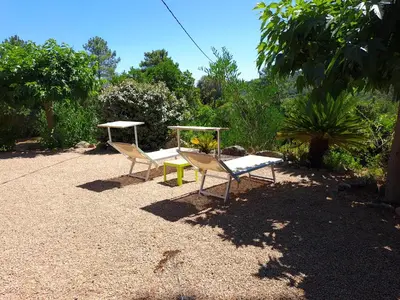 two chairs and a table in a yard at Villa avec piscine hors sol à 10mn de la plage in Lecci