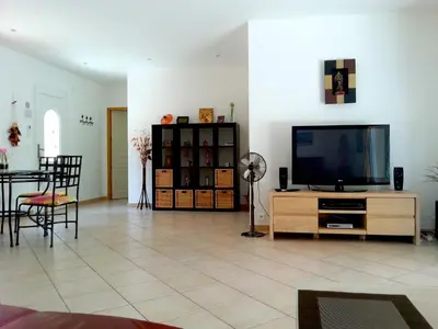 a living room with a flat screen tv on a wooden entertainment center at Villa avec piscine hors sol à 10mn de la plage in Lecci