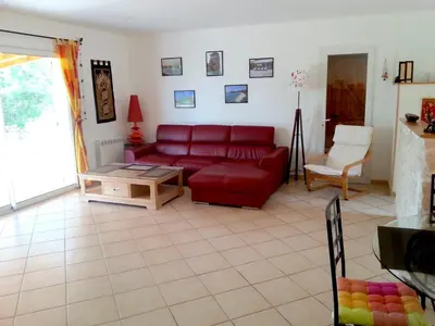 a living room with a red couch and a table at Villa avec piscine hors sol à 10mn de la plage in Lecci