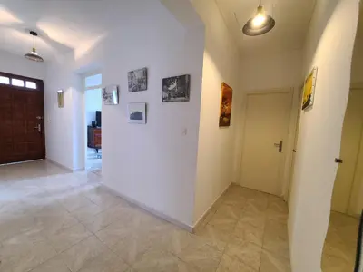 a hallway with a white wall with pictures on it at A CASA DI LOULOU e MARIA in Furiani