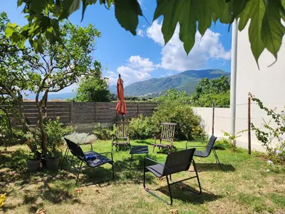 a group of chairs and an umbrella in a yard at A CASA DI LOULOU e MARIA in Furiani