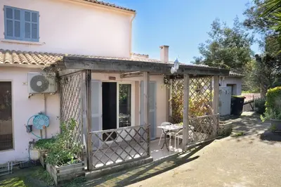 a white house with a porch with a table at Studio Indépendant avec Terrasse in Furiani
