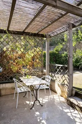 a patio with a table and chairs under a pergola at Studio Indépendant avec Terrasse in Furiani