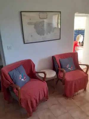 a living room with two chairs and a table at appartement climatisé 35 m2 pour 1 couple - piscine partagée - in Porto-Vecchio
