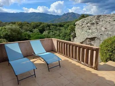two blue chairs sitting on a balcony with a view at mini villa studio 1 pièce 21 m2 pour 2 personnes piscine partagée climatisation in Porto-Vecchio