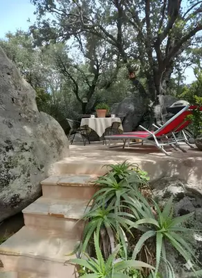 a garden with rocks and plants and flowers at studio 1 pièce 16 m2 climatisé 2 personnes piscine partagée in Porto-Vecchio