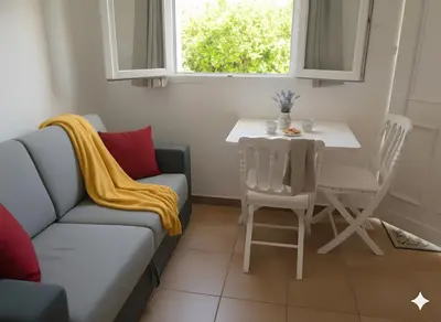 a living room with a couch and a table at studio 1 pièce 16 m2 climatisé 2 personnes piscine partagée in Porto-Vecchio