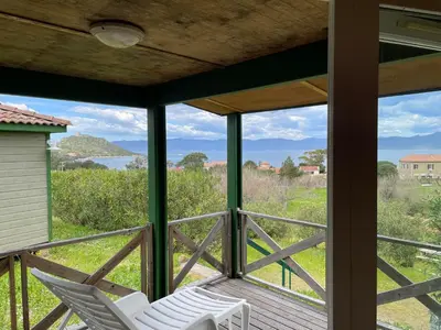 a porch with two chairs and a view of the ocean at Lavallee in Campomoro