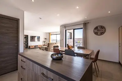 a kitchen and dining room with a table and a clock at Afa, proche d Ajaccio, Magnifique Villa 4 pers avec Piscine privée et vue montagne in Afa