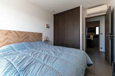 a bedroom with a blue comforter on a bed at Afa, proche d Ajaccio, Magnifique Villa 4 pers avec Piscine privée et vue montagne in Afa