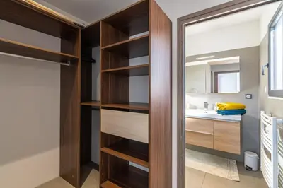 a bathroom with wooden shelves and a sink at Afa, proche d Ajaccio, Magnifique Villa 4 pers avec Piscine privée et vue montagne in Afa