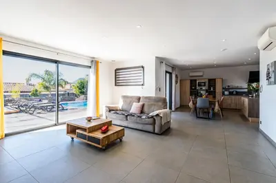 a living room with a couch and a table at Afa, proche d Ajaccio, Magnifique Villa 4 pers avec Piscine privée et vue montagne in Afa
