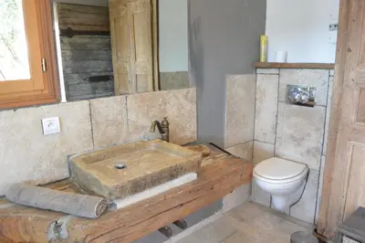 a bathroom with a wooden sink and a toilet at Villa CAROLE Piscine privée Spa Fautéa in Zonza