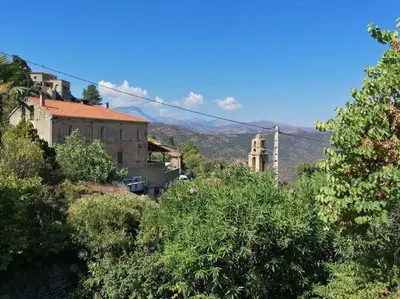 a group of buildings and a church and trees at Maison Lama in Lama