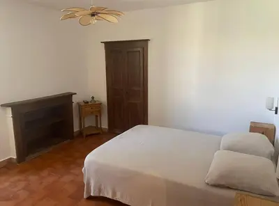 a bedroom with a white bed and a ceiling fan at Maison Lama in Lama