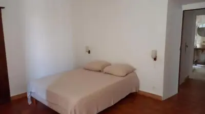 a white bedroom with a bed with two pillows on it at Maison Lama in Lama