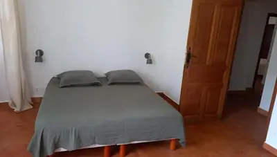 a bedroom with a bed and a wooden door at Maison Lama in Lama