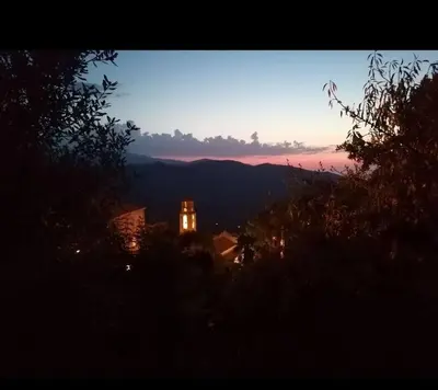 a view of a building with a clock tower at sunset at Maison Lama in Lama