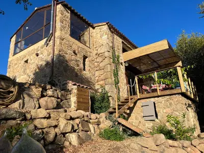 a stone house with a window and a stone wall at Maison typique Corse écologique in Coti-Chiavari