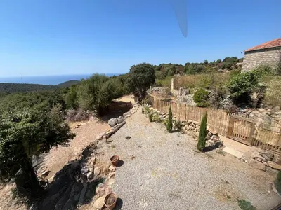 a view of a hill with a house and a fence at Maison typique Corse écologique in Coti-Chiavari