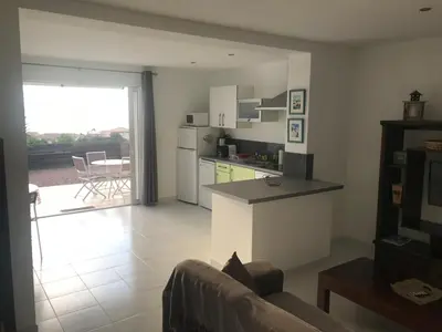 a kitchen and living room with a couch and a table at Clement - Rez de villa - Vue Mer in Sari Solenzara