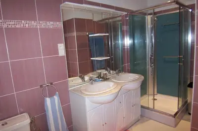 a bathroom with two sinks and a shower at Clement - Rez de villa - Vue Mer in Sari Solenzara