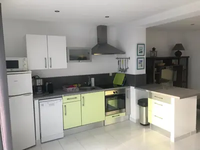 a kitchen with white and green cabinets and appliances at Clement - Rez de villa - Vue Mer in Sari Solenzara