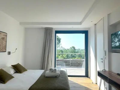 a bedroom with a bed and a large window at Appartements Les Lofts de Sainte-Lucie-de-Porto-Vecchio in Sainte-Lucie de Porto-Vecchio