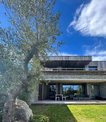 a building with a tree in front of it at Appartements Les Lofts de Sainte-Lucie-de-Porto-Vecchio in Sainte-Lucie de Porto-Vecchio