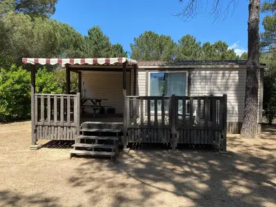 a small cabin with a porch and a picnic table at Camping Olva *** in Sartène